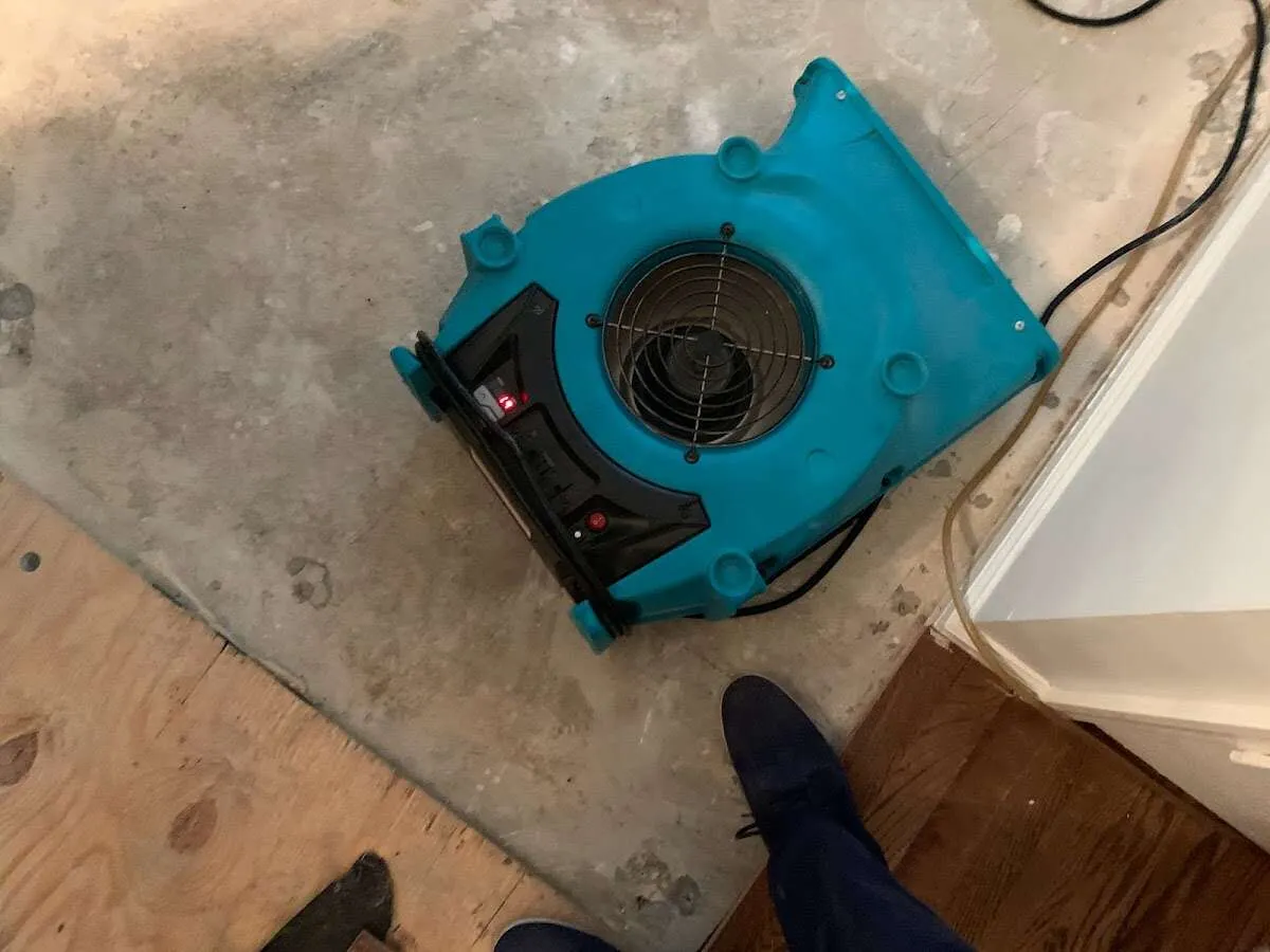 Air mover drying subfloor during Commercial Water Damage Restoration in Asbury Lake